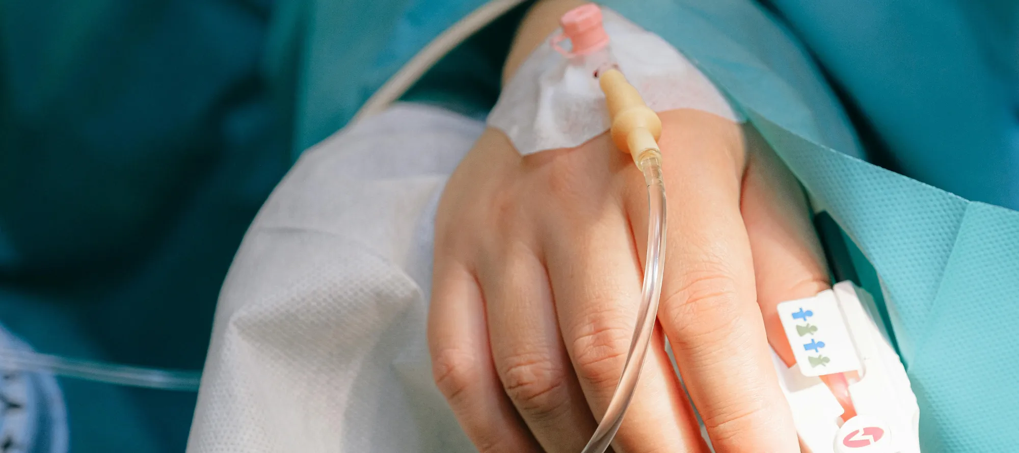 Hand mit Infusion im OP Saal
