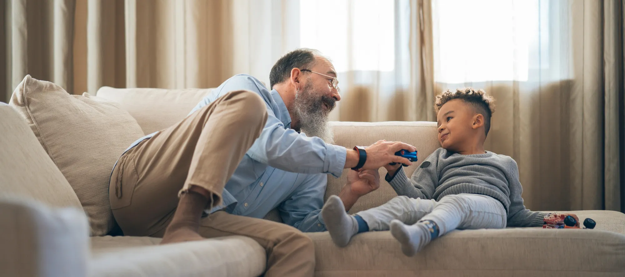 Vater mit Kind auf dem Sofa beim Spielen