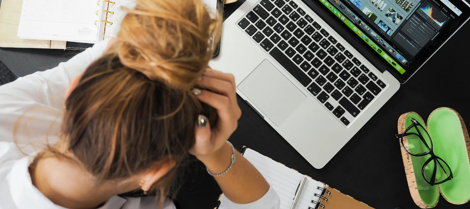 Frau beim Arbeiten steckt den Kopf in die Hand